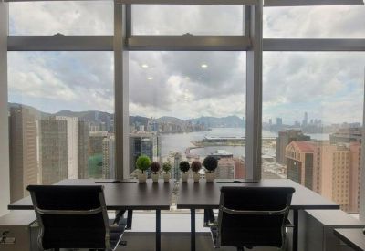 Bright workspace with a large window overlooking the Victoria Harbour skyline.