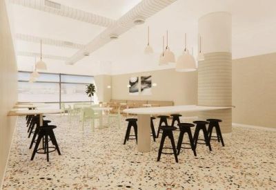 Modern communal area with tall black stools and round white tables.