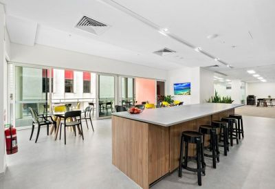 Spacious communal kitchen area with a large wooden island bench and balcony access.