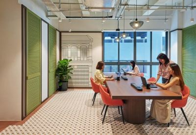 Large wooden conference table in a modern meeting room with patterned carpet and green wall panels.