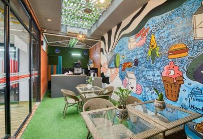Vibrant communal breakout area with a colorful wall mural and artificial grass flooring.