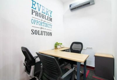 Private office featuring an L-shaped desk and motivational wall quote.