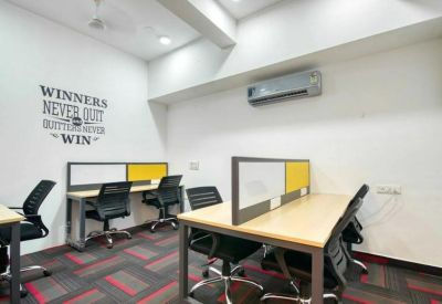 Coworking space with dual-sided workstations and wall-mounted air conditioning.