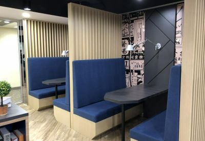 Semi-private blue upholstered meeting booths with wood slat partitions.