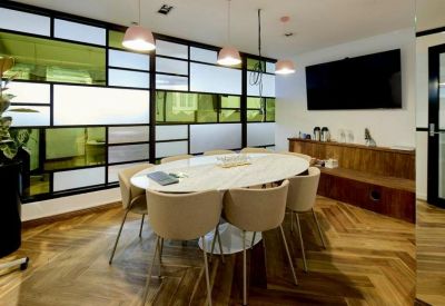 Professional meeting room with an oval marble table and modern pendant lighting.