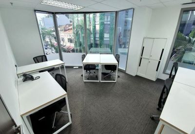 Bright open-plan office suite with white desks and large windows overlooking the street.