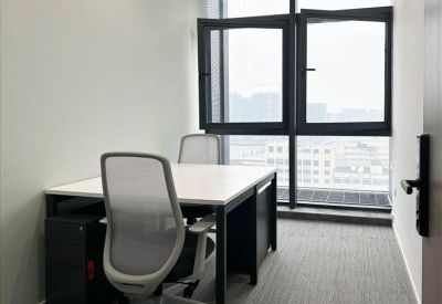 Private office for two with white desks and large windows overlooking the city.