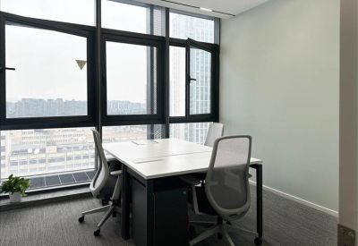 Small office setup with a corner window and potted plant.