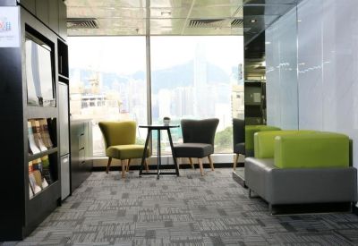 Bright breakout area with a small table, colorful seating, and city views.