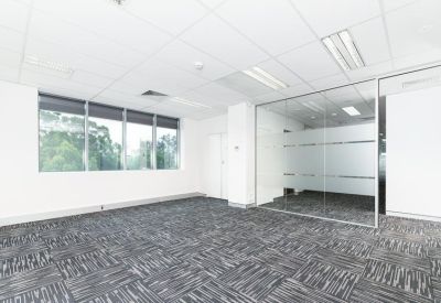 Large windowed office area looking through glass walls towards a central corridor.