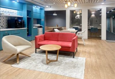 Vibrant communal lounge area with a red sofa, white armchair, and blue cabinetry.