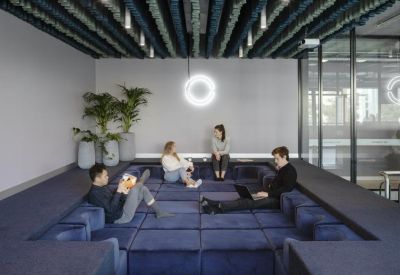 Modern breakout lounge featuring a sunken velvet seating pit and creative acoustic ceiling baffles.