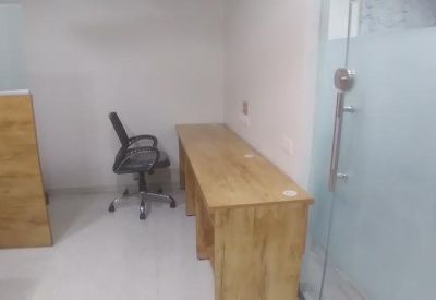 Simple office workstation with a long wooden desk and frosted glass partition.