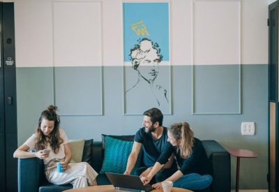 Collaborative breakout space with a blue sofa and creative wall art.