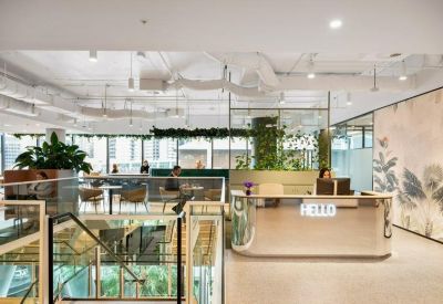 Modern lobby with white reception desk and green plants.
