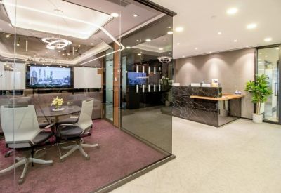 Professional reception area with a dark marble desk and a nearby glass-walled meeting room.