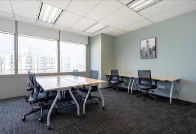 Bright private office featuring four workstations and a city-themed wall art piece.