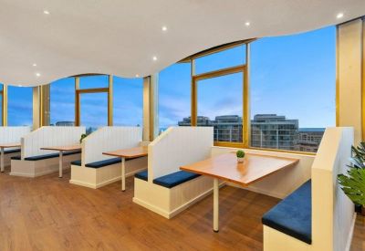 Bright breakout area with booth seating and panoramic coastal views.