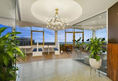 Spacious reception lobby with polished terrazzo floors and potted greenery.