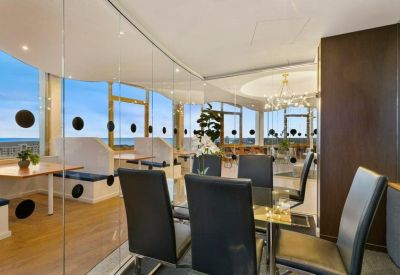 Professional internal office suite with black leather chairs and glass walls.