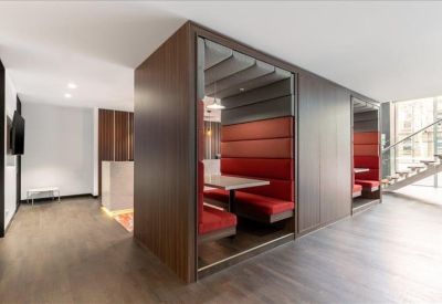 Private semi-enclosed booths with red cushioned seating and wood accents.