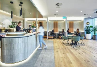 Stylish office kitchen and café area with a curved counter and various seating options.