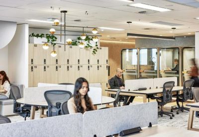 Modern coworking space featuring a circular desk and a chandelier with integrated greenery.