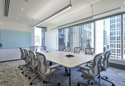 Large professional conference room with a long wooden table and panoramic city views.