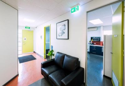Reception area with black couch and green doors