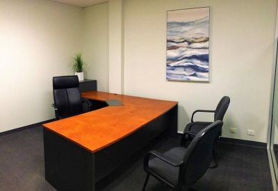 Private office with a wooden desk and two black chairs