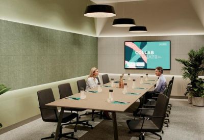 Professional boardroom with a large central table, green acoustic wall, and integrated technology.
