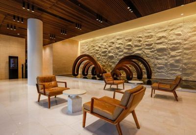 Spacious lobby featuring a textured feature wall and leather armchairs.