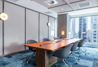 Sleek wooden boardroom table under minimalist pendant lighting.