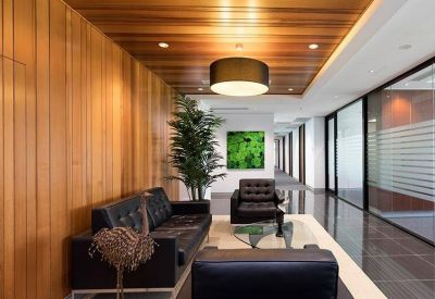 Sophisticated reception lounge with timber-paneled walls, leather seating, and a large drum pendant light.