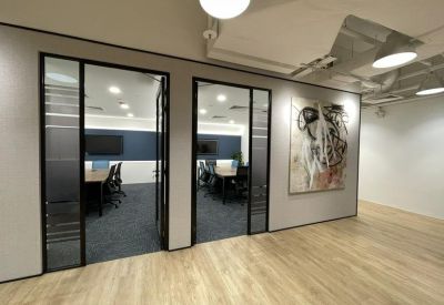 Sleek glass-fronted meeting rooms and modern abstract wall art.