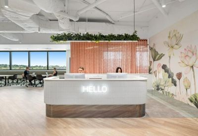 Reception area with a white marble desk and floral wall mural.