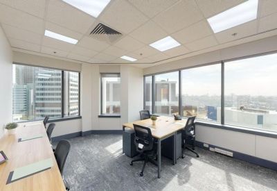 Bright multi-person office suite with large windows and city views.