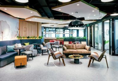 Spacious communal lounge with diverse seating, a brown leather sofa, and modern light fixtures.