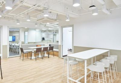 Bright coworking space with high-top seating and wooden floors.