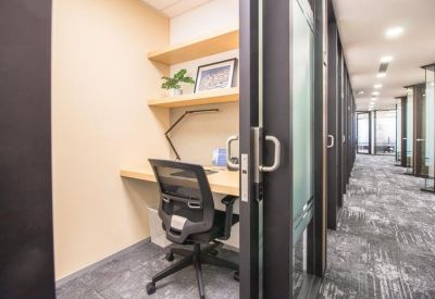 Private single-person workstation booth with a sliding door and wooden shelving.