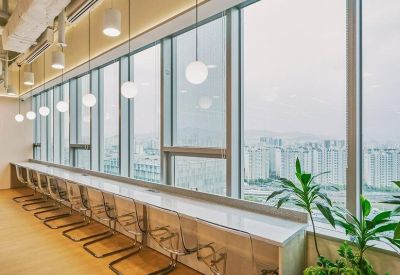 Sleek window-side high bar with transparent stools overlooking a panoramic city skyline.