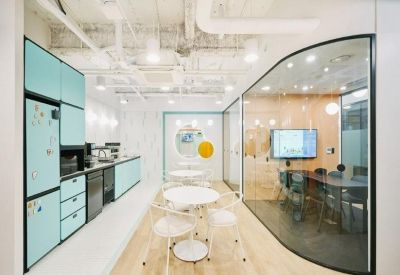 Private meeting room with glass walls, light blue cabinetry, and a round white table.