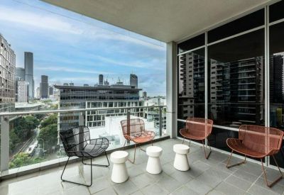 Private outdoor balcony with contemporary wire chairs and views of the city skyline.