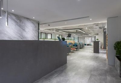 Modern reception area with a dark textured desk and marble feature wall.