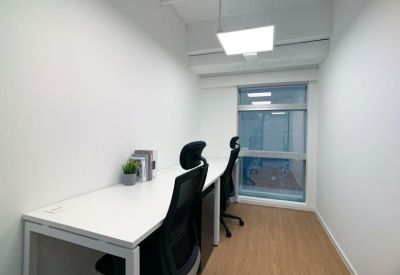 Private two-person internal office suite with white desks and black ergonomic chairs.