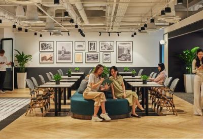 Spacious communal lounge with diverse seating, dining tables, and a gallery wall of framed art.