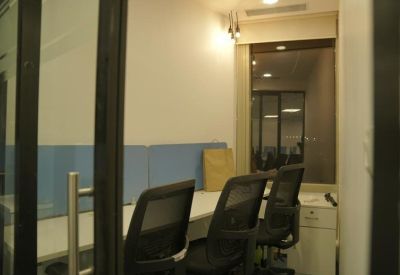 Narrow office suite featuring a blue privacy screen and ergonomic mesh chairs.