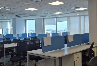 Spacious open-plan workspace at Lodha Supremus with rows of modern white desks and blue privacy dividers.