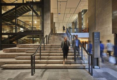 Spacious modern lobby with grand stone stairs and glass partitions.