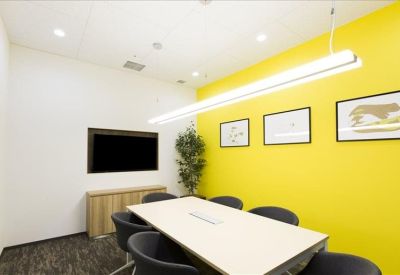 Modern semi-private meeting booth with built-in seating and a city skyline mural.